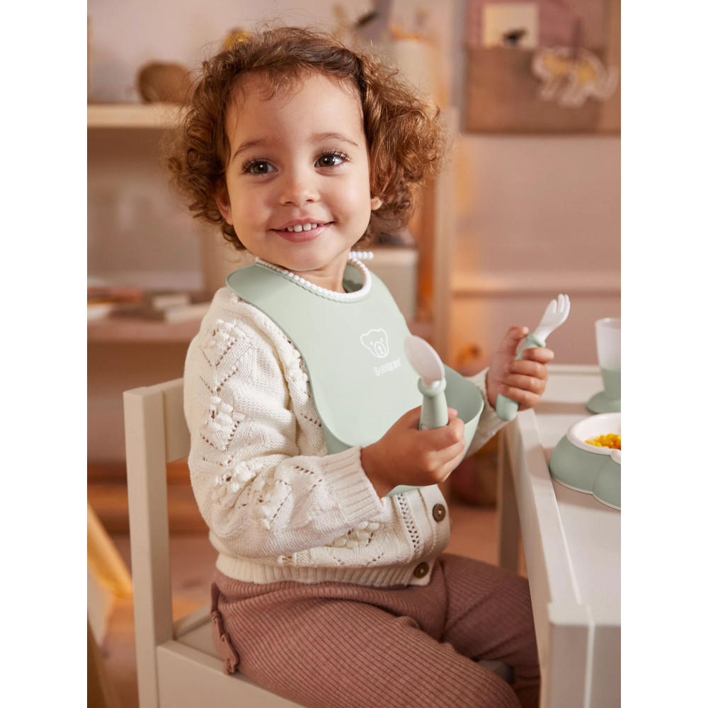 Petite fille en situation avec le coffret repas bébé vert pastel Babybjorn