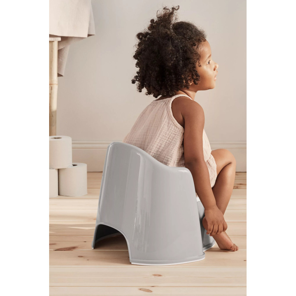 Petite fille sur le pot toilette fauteuil gris et blanc Babybjorn